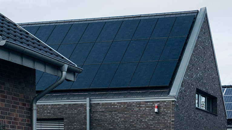 Mehrere Photovoltaik-Module auf einem Dach von unten fotografiert